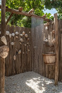 an outdoor shower made out of driftwood and seashells is featured in this bathroom