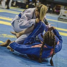 two women are in the middle of a competition, one is on the ground while the other