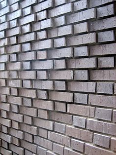 a brick wall that is made out of small bricks and has no mortars on it