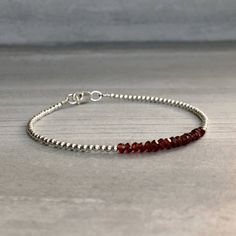 This gemstone bracelet features small genuine Garnet stones. The faceted garnet beads are a beautiful vibrant red hue. This piece is timeless, yet unique. A perfect gift for a birthday or for your Valentine. The tiny round beads frame the faceted gemstones beautifully. At checkout, choose to buy a Garnet bracelet with gold or sterling silver beads. * METAPHYSICAL PROPERTIES OF GARNETS * courage energy love passion self confidence transformation Free gift with every crystal jewelry purchase from Bead Frame, Garnet Bracelet, Garnet Jewelry, Garnet Stone, Faceted Gemstones, Red Garnet, Gift For Wife, Sterling Silver Bead, Gemstone Bracelet