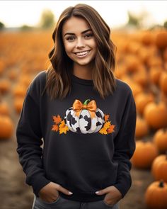 Step into the season in style with our Pumpkin Patch Cow Print Sweatshirt. Featuring a playful cow-print pumpkin adorned with autumn leaves and a vibrant orange bow, this cozy sweatshirt is perfect for pumpkin patch visits, fall festivals, or cozy evenings. Available in black, this design adds a touch of farmhouse charm to your fall wardrobe. Crafted with comfort in mind, it's a must-have for any autumn-lover. Casual Cow Print Tops For Fall, Orange Crew Neck Sweatshirt For Fall, Fall Cow Print Cotton Tops, Quilted Pumpkin Sweatshirt, Cow Print Sweatshirt, Pumpkin Patch Sweatshirt, Cheap Cat Print Sweatshirt For Fall, Casual Fall T-shirt With Cow Print, Fall Leopard Pumpkin Shirt