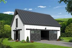 a white barn with a black roof and two garage doors on the side of it