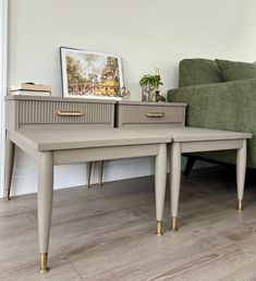 two tables sitting next to each other on top of a wooden floor in front of a green couch