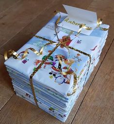 a stack of folded cards on top of each other with gold ribbons tied around them