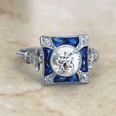 Gorgeous Art Deco style diamond and sapphire engagement ring handcrafted in platinum. It centers a fine old European cut diamond weighing 1.02 carat approximately I-J color VS clarity. 8 blue sapphires surround the center stone. The ring is accented with 0.10 carat of old cut diamonds. Ring size 6.75 US. Birthstone: April/September Condition: Excellent. Brand New. - 14 day return policy, no questions asked. - Free insured shipping in the US. - International shipping available. - Courtesy ring si Diamond And Sapphire Engagement Ring, Emerald Eternity Band, Diamond Sapphire Engagement Ring, Wedding Rings Solitaire, Maltese Cross, Diamonds Ring, Sapphire Engagement Ring, European Cut Diamonds, Art Deco Diamond