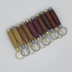 a row of wooden and metal keychains with rings on them, all in different colors