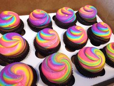 there are many cupcakes with rainbow frosting on them