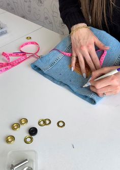 a woman sitting at a table with some sewing supplies