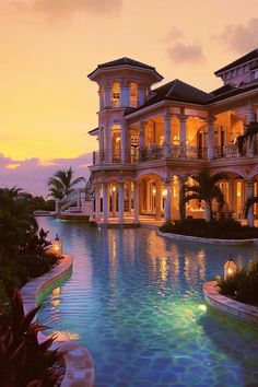 a large mansion with a pool in front of it at sunset or sunrise time,