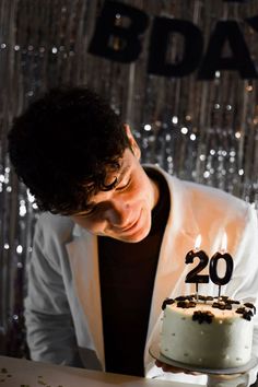 a young man blowing out the candles on his birthday cake