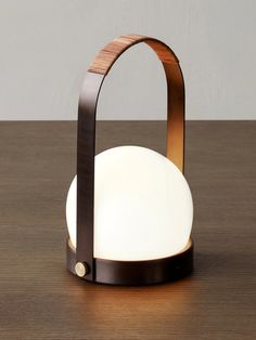 a lamp that is sitting on top of a wooden table next to a white light