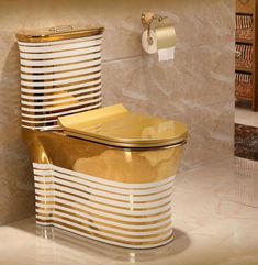 a gold toilet sitting next to a roll of toilet paper