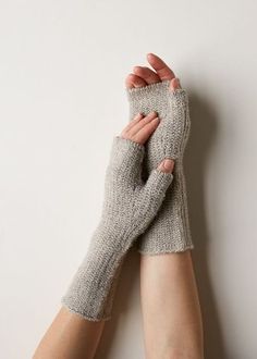 a woman's hands with knitted gloves on