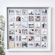 a white frame with pictures and flowers on the table next to it is an arrangement of wedding photos