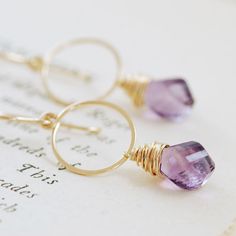 Amethyst hoop earrings made with beautiful purple amethyst twist briolettes dangling from hoops I've handcrafted out of 14k gold filled wire. I love this faceted twist shape-- it really shows off the gorgeous color of these gems and looks wonderful against the warm gold. This makes a great autumn accessory and is versatile enough to wear all year long. Total length is approximately 1 3/4 inches (4.4 cm), and the amethyst briolettes are about 12 mm x 5.5 mm. I can make these in 14k gold fill (pic Elegant Purple Small Hoop Earrings, Elegant Small Hoop Purple Earrings, Purple Gemstone Hoop Earrings, Purple Briolette Wire Wrapped Earrings, Purple Amethyst Hoop Jewelry, Purple Amethyst Hoop Earrings For Gift, February Birthstone Jewelry, Jewelry Purple, Amethyst Gold