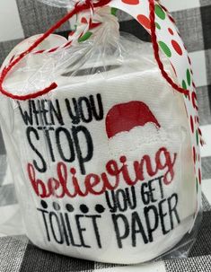 a white toilet paper wrapped in plastic on top of a black and white checkered table cloth