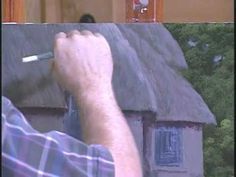 a man is writing on the side of a house with a pen in his hand