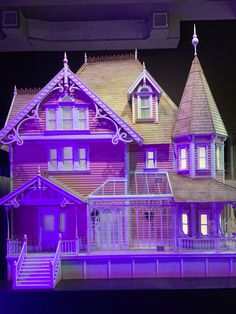 a large purple house on display in front of a dark background