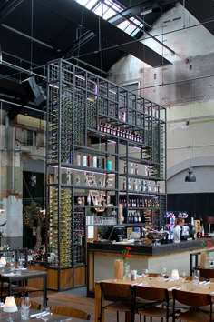 an empty restaurant with tables and chairs in front of the bar, filled with wine bottles