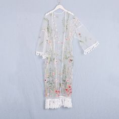 Welcome to my shop, I am in China. It will need around 30 days for international orders. Please consider the time when placing order. Long bohemian kimono,perfect for a casual day out or as a swimsuit cover up. Material: embroidery mesh fabric Size: cuff opening to cuff opening: 55 inches (140cm) cuff width: 10 inches (25cm) chest: 25.5 inches( 65cm) flat length include fringe: 49 inches (125cm) Care: Wash in cold water Hand washing recommended Gentle machine wash Hang to dry Maybe you will like Long Tasseled Kimono For Spring, White Floral Kimono For Festival, White Floral Print Kimono For Festival, Spring Kimono With Tassels, White Lace Trim Kimono For Wedding, White Wedding Kimono With Lace Trim, White Lace Trim Wedding Kimono, Wedding White Kimono With Lace Trim, Elegant Floral Embroidered Summer Kimono