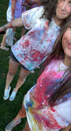 two girls covered in paint posing for the camera