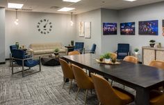 a conference room with chairs, tables and pictures on the wall