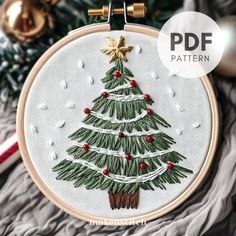 a christmas tree with red berries and gold ornaments is featured in this hand embroidery pattern