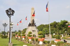 flags fly in the wind next to a monument