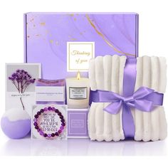 a purple gift box with candles, soaps and other items