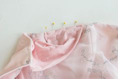 a pink dress with silver sequins on it and some pins in the back