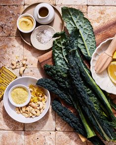 there are many different foods on the table together, including lemons and spinach