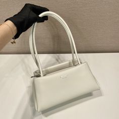 SHOP MORE LUXURY PRODUCTS HERE Description Prada Small Bag White For Women, Women’s Bags 9.8in/25cm 1BA368_2DDJ_F0009_V_OOO A study of the lines characterizes this smallÃƒÂ¯Ã‚Â¿Ã‚Â½ÃƒÂ¯Ã‚Â¿Ã‚Â½ÃƒÂ¯Ã‚Â¿Ã‚Â½ÃƒÂ¯Ã‚Â¿Ã‚Â½ handbag. It stands out for its absolutely elegant silhouette emphasized by the long, narrow handle. This three-pocket accessory is decorated with the metal lettering logo. Size: 25 x 13.5 x 13 cm /9.8 x 5.3 x 5 inches (Length x Width x Height) WhiteHandlesMetal hardwarePrinte Prada Small Bag, Dior Bucket Hat, White Handles, Metal Lettering, Louis Vuitton Shirt, Chanel Shirt, Chanel Tote, Lettering Logo, Small Handbag