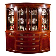 a wooden china cabinet with glass doors and shelves on the front, decorated with figurines