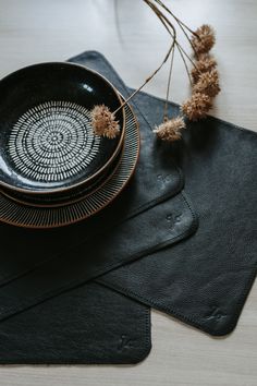 a black plate and two place mats on a table