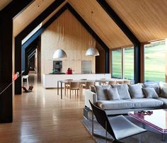 a living room filled with lots of furniture and large windows next to a dining table