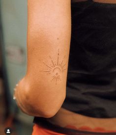 a woman with a sun tattoo on her arm