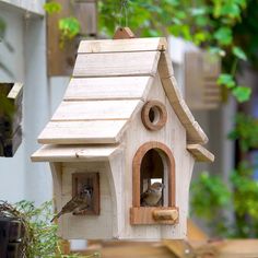 a wooden bird house with two birds in it