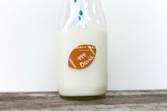 a glass bottle filled with milk sitting on top of a wooden table