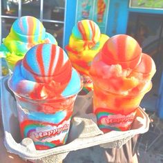 there are three ice creams that are in the cup on the tray and one is rainbow