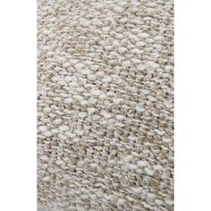 a beige and white rug with lots of small balls on the bottom, in front of a