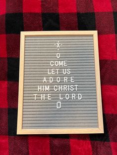 a framed sign that reads, come let us adore him christ the lord o