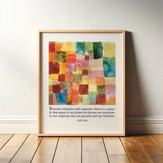 a framed art print with a quote on it in front of a white wall and wooden floor