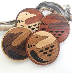 four wooden coasters with birds painted on them