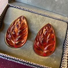 two orange glass pieces sitting in a box