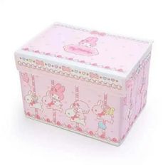 a pink box with hello kitty designs on the front and sides, sitting on a white surface