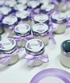 several small jars with purple ribbons around them