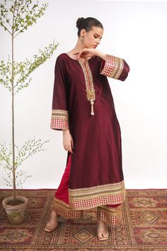 A maroon, raw silk, Kashmiri cut long kurta with Marori lace on the neck and sleeves. A pink tissue silk ajar pant lends a royal look to the suit. Finished with a matching tissue organza dupatta with pink border. 3-piece suit Ready to wear Festive Long Sleeve Tissue Silk Salwar Kameez, Festive Dabka Raw Silk Palazzo Set, Elegant Unstitched Churidar With Embroidered Border, Unstitched Elegant Churidar With Embroidered Border, Elegant Festive Salwar Kameez With Embroidered Border, Eid Traditional Wear With Dabka On Tissue Silk, Eid Traditional Wear In Tissue Silk With Dabka, Eid Traditional Dabka Tissue Silk Wear, Formal Raw Silk Churidar With Resham Embroidery