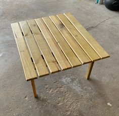 a wooden table sitting on top of a cement floor