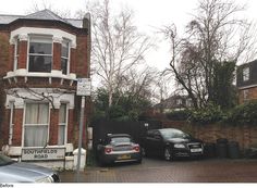 two cars parked in front of a brick building with white windows and black fence around it