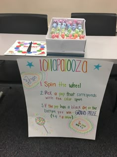 a table with a sign that says, i spin the wheel and some sort of candy